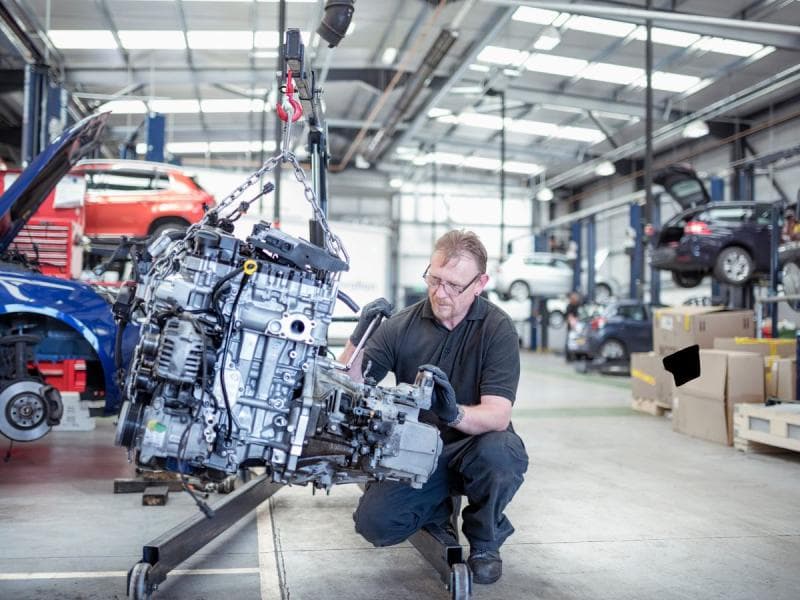 Technician working with a remanufactured engine in a professional workshop