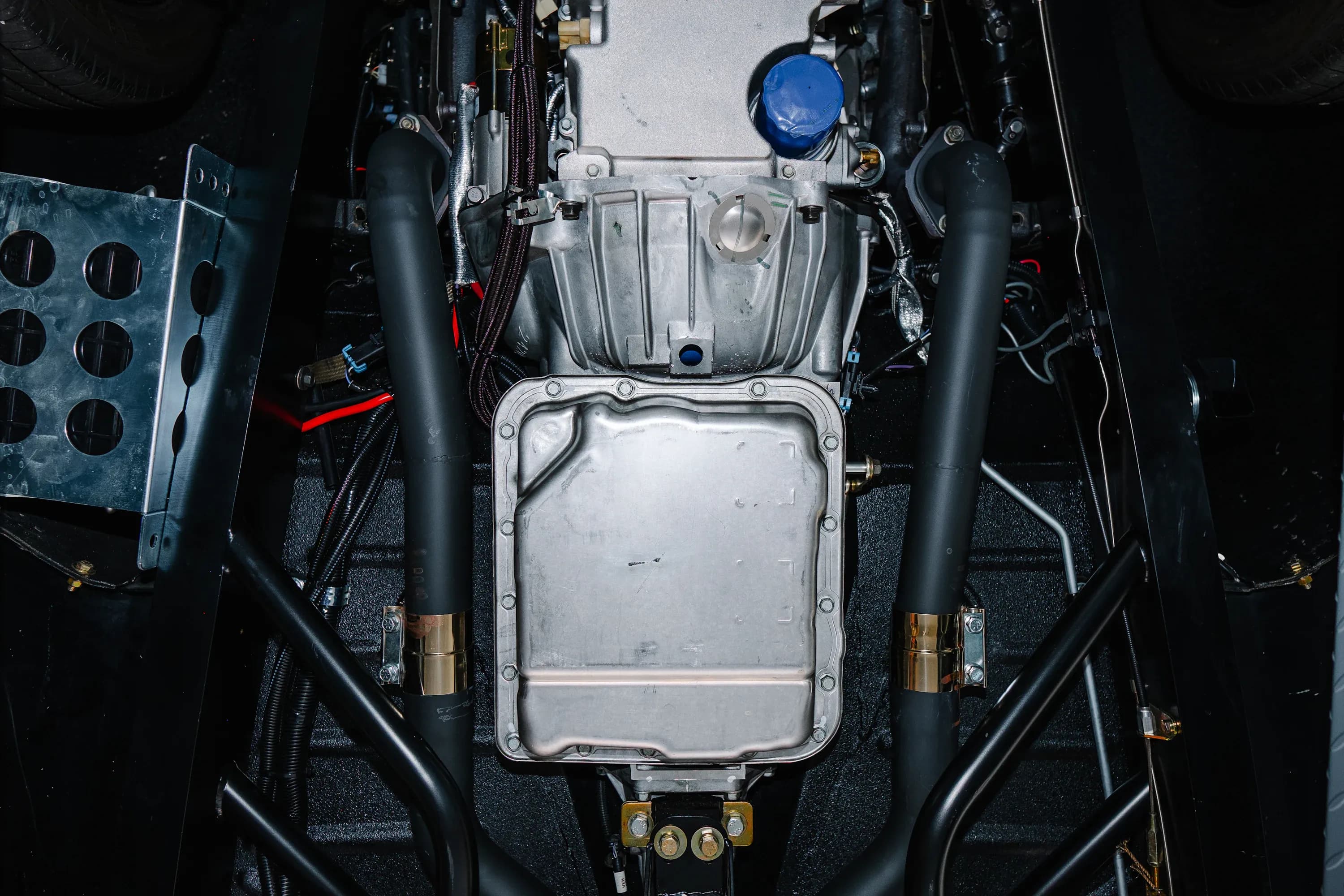 Underside of a vehicle showing the transmission and surrounding drivetrain components