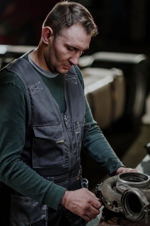 Mechanic inspecting a turbocharger component on a workshop bench