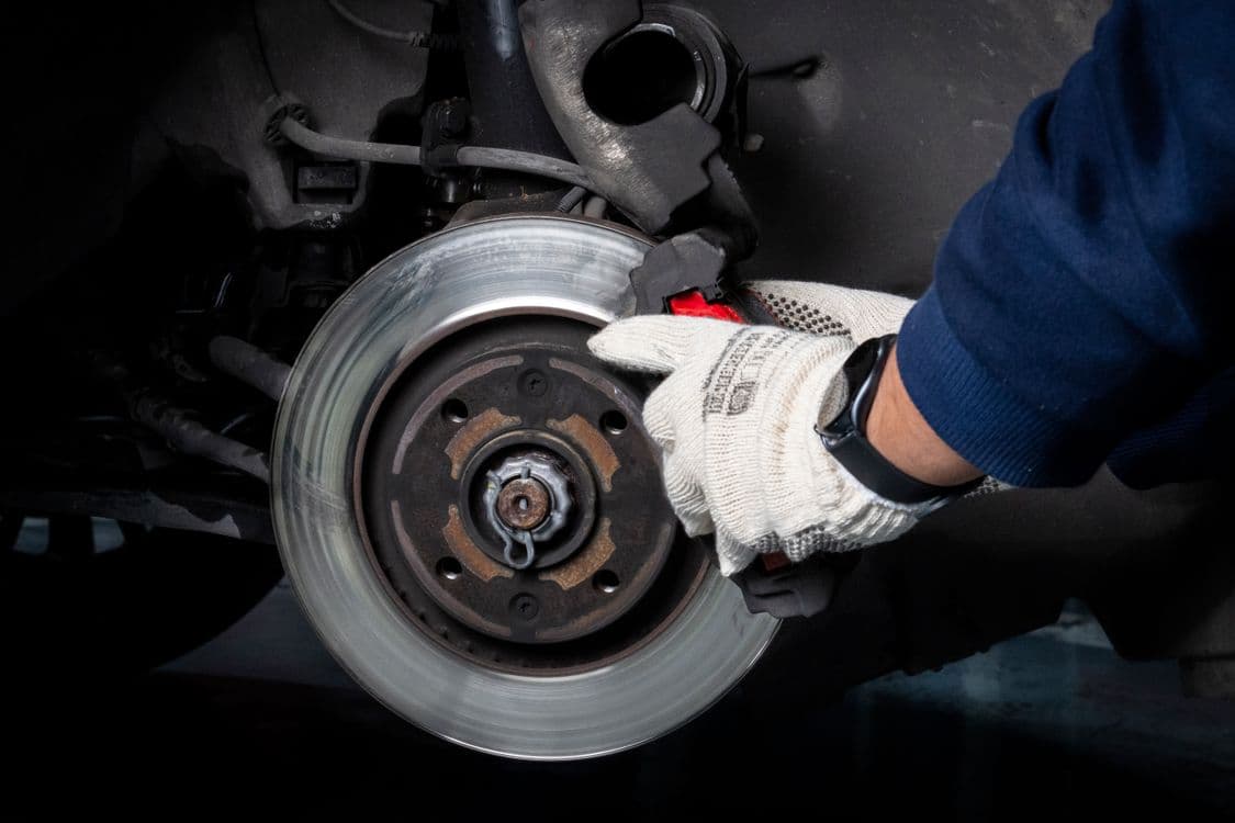 Mechanic servicing a vehicle brake system in a workshop