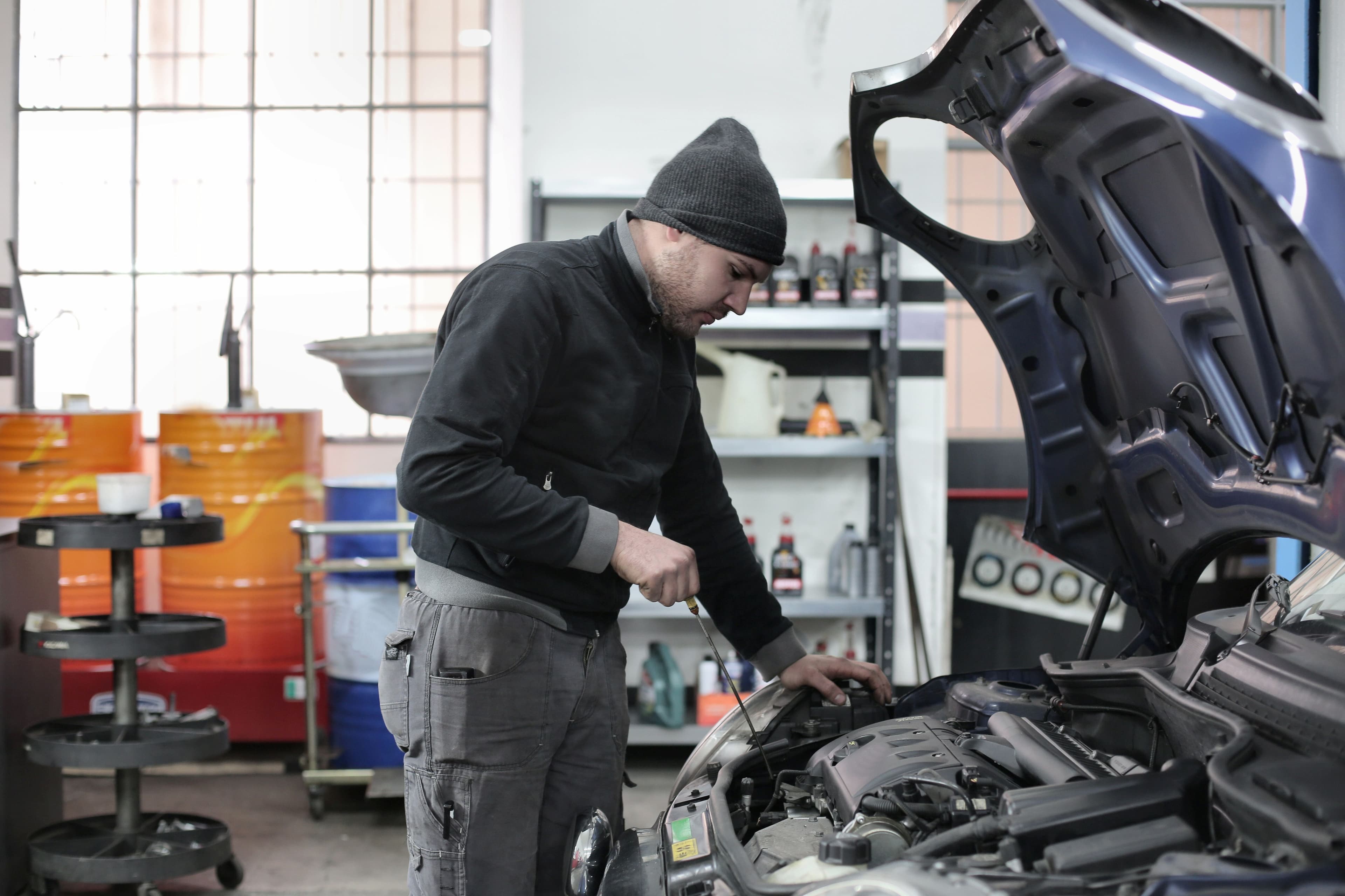 Mechanic inspecting an engine for a timing-chain rattle and cam timing fault