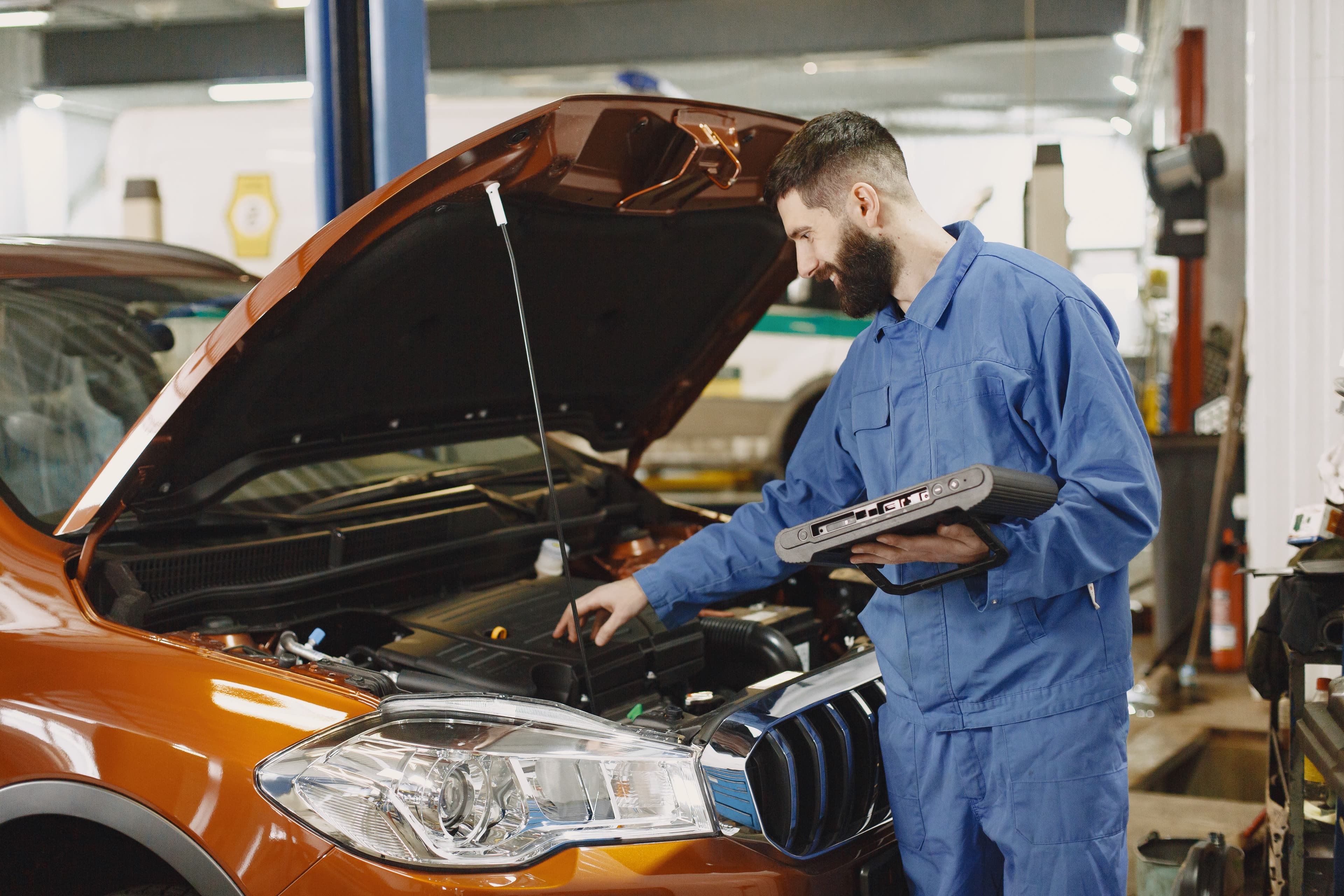Mechanic inspecting an engine in a professional automotive workshop