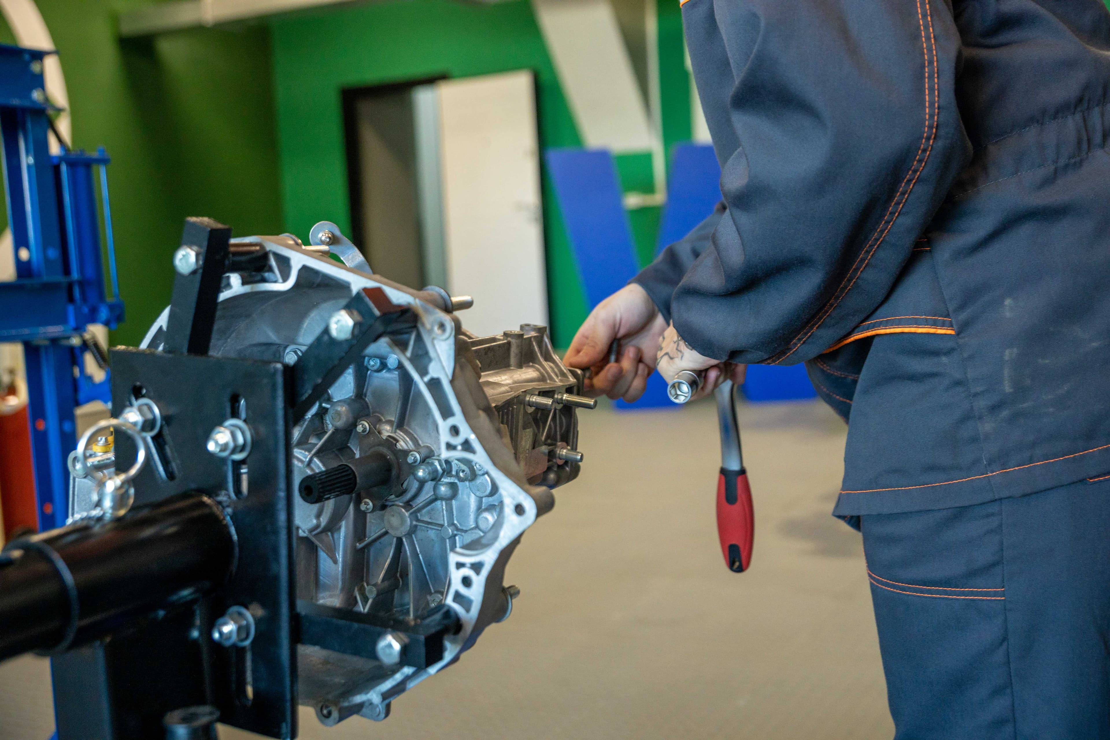 Mechanic working on an automatic transmission assembly at a workshop bench