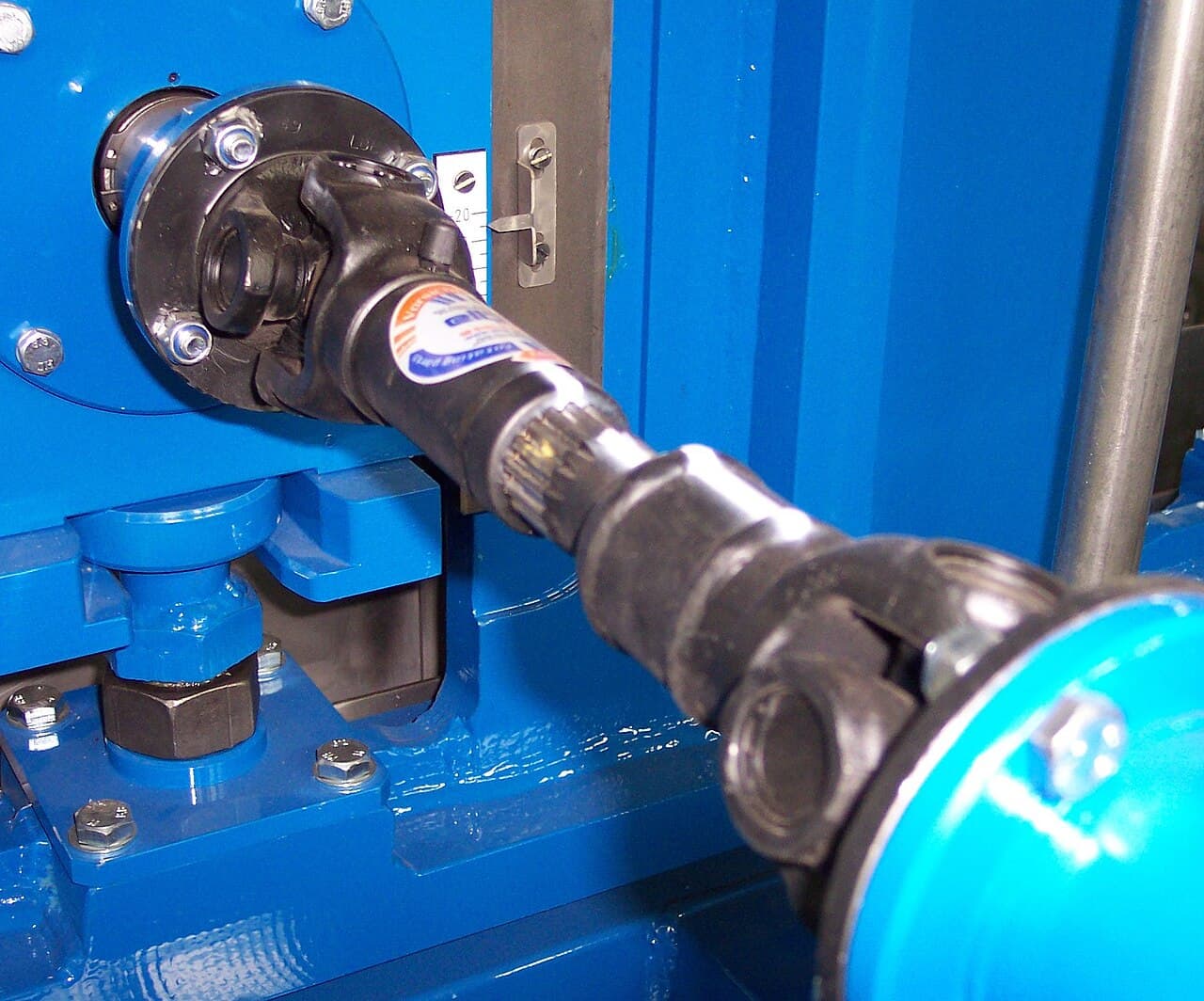 Drive shaft with universal joints at each end and a slip spline in the center